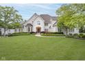 Striking stone home with lush lawn, gardens, and meticulous landscaping at 12192 Woods Bay Pl, Carmel, IN 46033