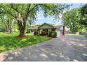 A ranch-style home with attached garage and a long driveway surrounded by mature trees and landscaping at 13172 E 116Th St, Fishers, IN 46037