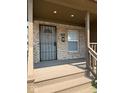 Front porch view with brick accents, secured front door, and a small window for natural lighting at 1421 S Meridian St, Indianapolis, IN 46225