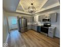 Updated kitchen with stainless steel appliances, gray cabinetry, and modern light fixture at 1421 S Meridian St, Indianapolis, IN 46225