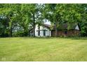 Mature trees surround this house with manicured lawn and neutral colored brick and siding at 15812 Joliet Rd, Westfield, IN 46074