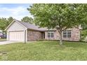 Inviting single-story home with a brick facade, attached garage, and green lawn at 1631 Wilford Ln, Indianapolis, IN 46229