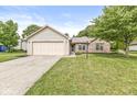 Attractive single-story home featuring a brick facade, attached garage, and well-maintained lawn at 1631 Wilford Ln, Indianapolis, IN 46229