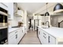 Modern kitchen featuring stainless steel appliances, white cabinets and countertops, and hardwood floors at 18956 Seaforth Way, Westfield, IN 46074