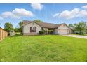 A cozy single-story home with a lush green lawn, complemented by vibrant red shutters at 2145 W Autumn Ln, Columbus, IN 47201