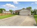 Front exterior of a single-story home featuring a spacious driveway and well-kept lawn at 2145 W Autumn Ln, Columbus, IN 47201