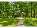 Stone path leads to outdoor gazebo featuring covered hot tub in wooded backyard at 2805 Fox E Ct, Martinsville, IN 46151