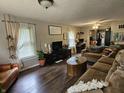 Spacious living room with hardwood floors, comfortable seating, and bright windows, perfect for relaxing and entertaining guests at 29 Home Ave, Markleville, IN 46056