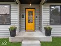Inviting entryway with a bright yellow door, potted plants, and a cozy welcome mat at 31 Mckenzie St, Shelbyville, IN 46176