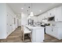 Beautiful kitchen with white cabinets, stainless steel appliances, an island with seating, and pendant lights at 3142 Balsamroot Rd, Greenwood, IN 46143