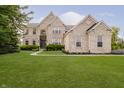 Stunning two-story brick home with manicured lawn, professional landscaping, and basketball hoop at 3876 Kegler Way, Carmel, IN 46074