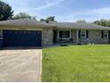 Charming single-story home with a brick facade, blue garage door, and well-manicured lawn at 4343 W Fairview Rd, Greenwood, IN 46142