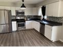 Modern kitchen with stainless steel appliances, black countertops, and ample cabinet space at 4343 W Fairview Rd, Greenwood, IN 46142