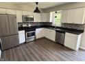 Modern kitchen featuring stainless steel appliances, white cabinets, and a stylish backsplash at 4343 W Fairview Rd, Greenwood, IN 46142