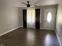 Inviting living room featuring wood-look floors, a ceiling fan, and a bright front door at 4343 W Fairview Rd, Greenwood, IN 46142
