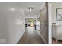 Bright hallway featuring wood-look floors, barn door accent, and modern decor creating a welcoming entrance at 4605 Clairmont Dr, Columbus, IN 47203