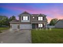 Two-story brick house with attached garage, green lawn and front porch at 5030 E 800 N, Columbus, IN 47203