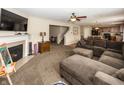Inviting living room featuring a cozy fireplace, a large sectional sofa, and an open layout that connects to the kitchen at 5215 Climbing Rose Pl, Indianapolis, IN 46254