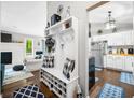 Bright foyer featuring wood floors, a coat rack with built-in bench, and views to the living room and kitchen at 6933 Grey Wolf Dr, , IN 46164