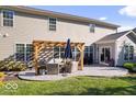 Cozy backyard patio featuring comfortable seating under a pergola, perfect for outdoor relaxation at 7249 Red Maple Dr, Zionsville, IN 46077