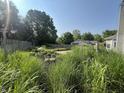 Spacious backyard featuring mature trees, lush grass, and a garden at 7657 Winding Creek Dr, Indianapolis, IN 46236