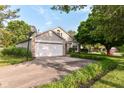 Home with an attached garage, lovely landscaping, and a well-maintained lawn at 7657 Winding Creek Dr, Indianapolis, IN 46236