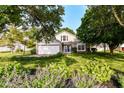 Beautiful home with an attached garage, green lawn, and lovely landscaping at 7657 Winding Creek Dr, Indianapolis, IN 46236