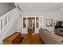 Open-concept living room with hardwood floors, white columns, and a view of bathroom at 831 Weghorst St, Indianapolis, IN 46203
