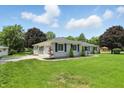 Well-maintained single-story home with a lush lawn and mature trees at 8510 N Carroll Rd, Indianapolis, IN 46236