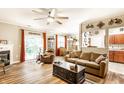 Bright living room with hardwood floors, ceiling fan, comfortable seating, and access to the backyard at 9263 Wadsworth Ct, Fishers, IN 46037