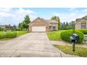 Charming brick home featuring an attached garage, well-manicured lawn, and welcoming curb appeal at 1105 Sarah Ct, Greenwood, IN 46142