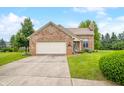 Charming brick home featuring an attached garage, well-manicured lawn, and welcoming curb appeal at 1105 Sarah Ct, Greenwood, IN 46142