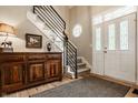 Inviting foyer features a staircase with modern iron railing and warm wood flooring at 11823 E 200 S, Zionsville, IN 46077