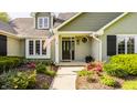 Welcoming front entrance with an American flag, beautiful landscaping and a black front door at 11823 E 200 S, Zionsville, IN 46077
