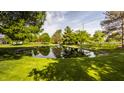 Scenic pond surrounded by mature trees and lush green grass, offering a serene outdoor space at 11823 E 200 S, Zionsville, IN 46077