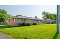 Well-maintained single-story house featuring stone, a mature lawn and an attached carport at 1460 W Mckay Rd, Shelbyville, IN 46176