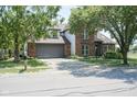 Brick home featuring a two-car garage, well-maintained lawn, and mature trees along a residential street at 17635 Willow Creek Way, Westfield, IN 46074