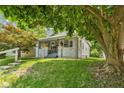 Inviting home boasting a covered porch with mature trees, and green lawn at 2433 E 16Th St, Indianapolis, IN 46201