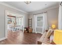 Bright room featuring beautiful hardwood floors, decorative trim, and open flow to dining area at 2433 E 16Th St, Indianapolis, IN 46201