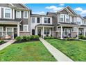 Well-maintained townhomes featuring stone accents, covered entries, and beautifully landscaped lawns at 3428 Thomas Jefferson St, Westfield, IN 46074
