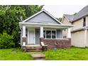 Charming bungalow with a brick-accented porch and fresh gray siding, located in a residential area at 3652 N Kenwood Ave, Indianapolis, IN 46208