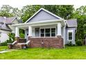 Bungalow-style home features gray siding, brick accents, and a welcoming front porch at 3652 N Kenwood Ave, Indianapolis, IN 46208