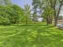 Spacious backyard featuring a well-manicured lawn and mature trees, perfect for outdoor activities at 4733 E 100 S, Anderson, IN 46017