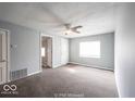 Bright living room featuring carpet flooring, fresh paint, and a ceiling fan at 5050 W Regent St, Indianapolis, IN 46241