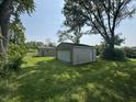 There are two detached garages in a backyard setting surrounded by healthy lawn at 5159 E Edgewood Ave, Indianapolis, IN 46237