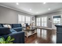 Spacious living room with hardwood floors, large windows, and a comfortable blue sectional sofa at 608 E 9Th St, Indianapolis, IN 46202