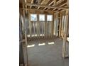 Spacious bedroom with wall studs, plywood flooring, and three bright windows at 637 Firefly Ct, Greenfield, IN 46140