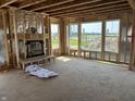 Unfinished living room featuring a fireplace, wall studs, and several windows offering scenic views at 637 Firefly Ct, Greenfield, IN 46140