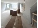 Spacious unfinished living room with boxes, neutral paint, and staircase with wooden railing at 7313 Bayview Run, McCordsville, IN 46055