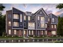 View of the new construction townhomes featuring brick and siding exteriors, colorful doors, and manicured lawns at 7339 Bayview Run, McCordsville, IN 46055